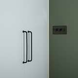 Sycamore Furniture Handle 224mm in Bronze, medium pull handle shown on a white cabinet against a green wall.