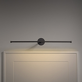 The Taylor Picture Light 580mm in bronze is mounted above a light-colored headboard.