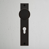 Bronze Onslow Long Plate Sprung Door Knob & Euro Lock with vertical backplate on textured white wall.