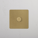 1G Two Way Dimmer Switch in Antique Brass on a white textured wall.