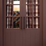 Harper Single Pull Handle 320mm in bronze on a wooden door with glass panels.