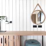 Bronze 2G retractive toggle switch on a striped wall, part of the 2G switches & dimmers collection.