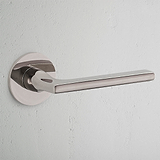 Clayton Flush Rose Polished Nickel door handle gleams on a light-colored wall.