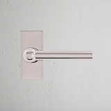 Harper Short Plate Sprung Door Handle in polished nickel on a textured white wall, part of 'Door Handles Short Plate'.