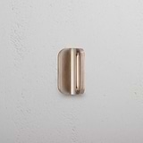 Oxford Furniture Handle 36mm in antique brass with elegantly curved edges, mounted on a white wall.