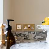 Antique Brass White 5A light socket in kitchen wall on top of marble counter top
