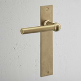 Harper Long Plate Sprung Door Handle in antique brass, designed for doors with a classic touch.