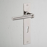 Polished nickel Harper Long Plate Sprung door handle with Euro lock keyhole, mounted on a white wall.