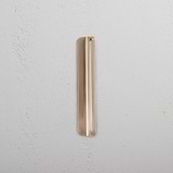 Oxford Furniture Handle 128mm in Antique Brass, a small pull handle, mounted on a textured white surface.