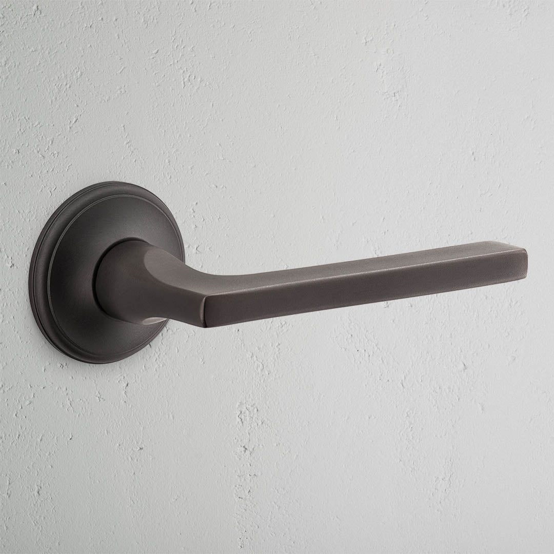 Clayton Fixed Door Handle in bronze with sleek design and circular base, ideal for enhancing door aesthetics.