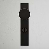 Bronze Onslow Long Plate Sprung Door Knob & Thumbturn on a textured white wall, elegant design.