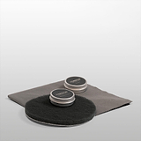 Two metal tins labeled 'Cognon' on gray circles and cloth, part of a Brass Restoration Kit for product maintenance.