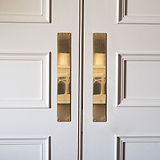 Harper Push Plate 400mm in Antique Brass on a white door, enhancing with vintage style and functionality.