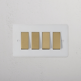 4G Two Way Rocker Switch in Paintable Antique Brass with White Finish on a textured white wall.