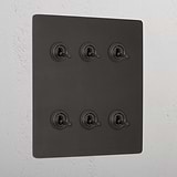 Bronze plate with six 6G toggle retractive switches for lighting control.