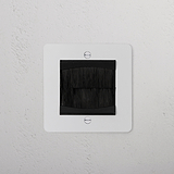 Paintable black single brush plate for 1G sockets, features square cable pass-through with black brush bristles.