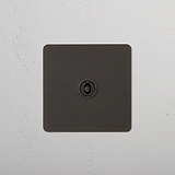 Bronze Switch Against Wallpapered Wall With Wooden Chair