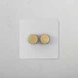 2G Dimmer Switch - Paintable Antique Brass with dual knobs on a white base against a textured white background.