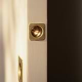 Close-up of a white sliding door edge with an antique brass Regent recessed pull handle.