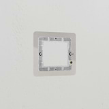 Polished nickel brass module plate, 1G 50mm size, shown against a white textured wall for decor.