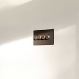 4G Two Way Dimmer Switch in bronze with four round knobs on a white wall. Elegant rectangular panel design.