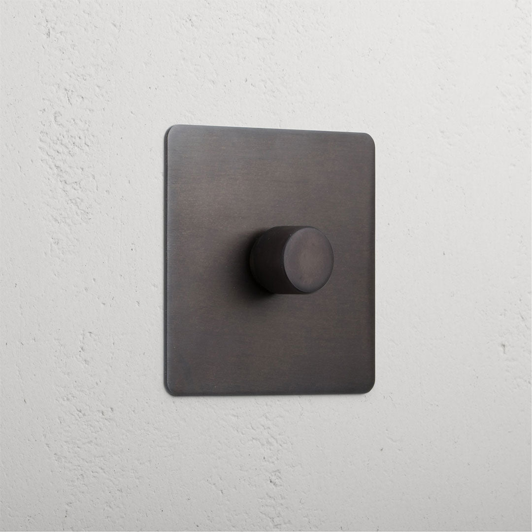 Bronze 1G digital dimmer switch with textured black square knob for controlling light intensity.