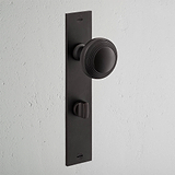 Bronze Poplar Long Plate Sprung Door Knob & Thumbturn set on a light gray background.