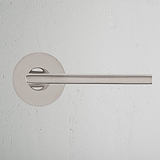 Clayton Flush Rose Unsprung Door Handle in Polished Nickel, displayed against a light gray wall.