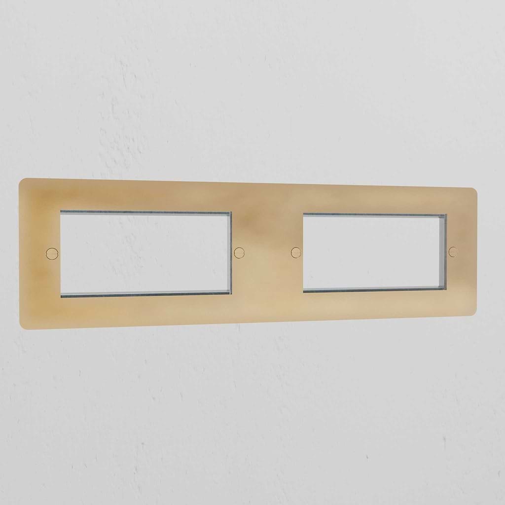 Antique Brass 4G 100mm Module Plate with four openings, showcasing a classic finish against a white wall.