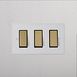 3G Two Way Rocker Switch in Paintable Antique Brass Black with three black switches, designed for elegant interiors.