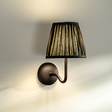 Medium Malvern Wall light in Deep Green at an angle affixed to a wall and turned on