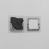 Clear Black 1G 50mm Module & Single Socket UK Plate on a white wall, featuring a sleek and modern design.