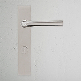 Apsley Long Plate Sprung Door Handle & Thumbturn, Polished Nickel, on white textured wall.