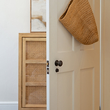 Bronze poplar unsprung door knob installed on a white door.