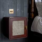 Harper T-Bar Furniture Handle in Antique Brass on a woven-front brown bedside cabinet.