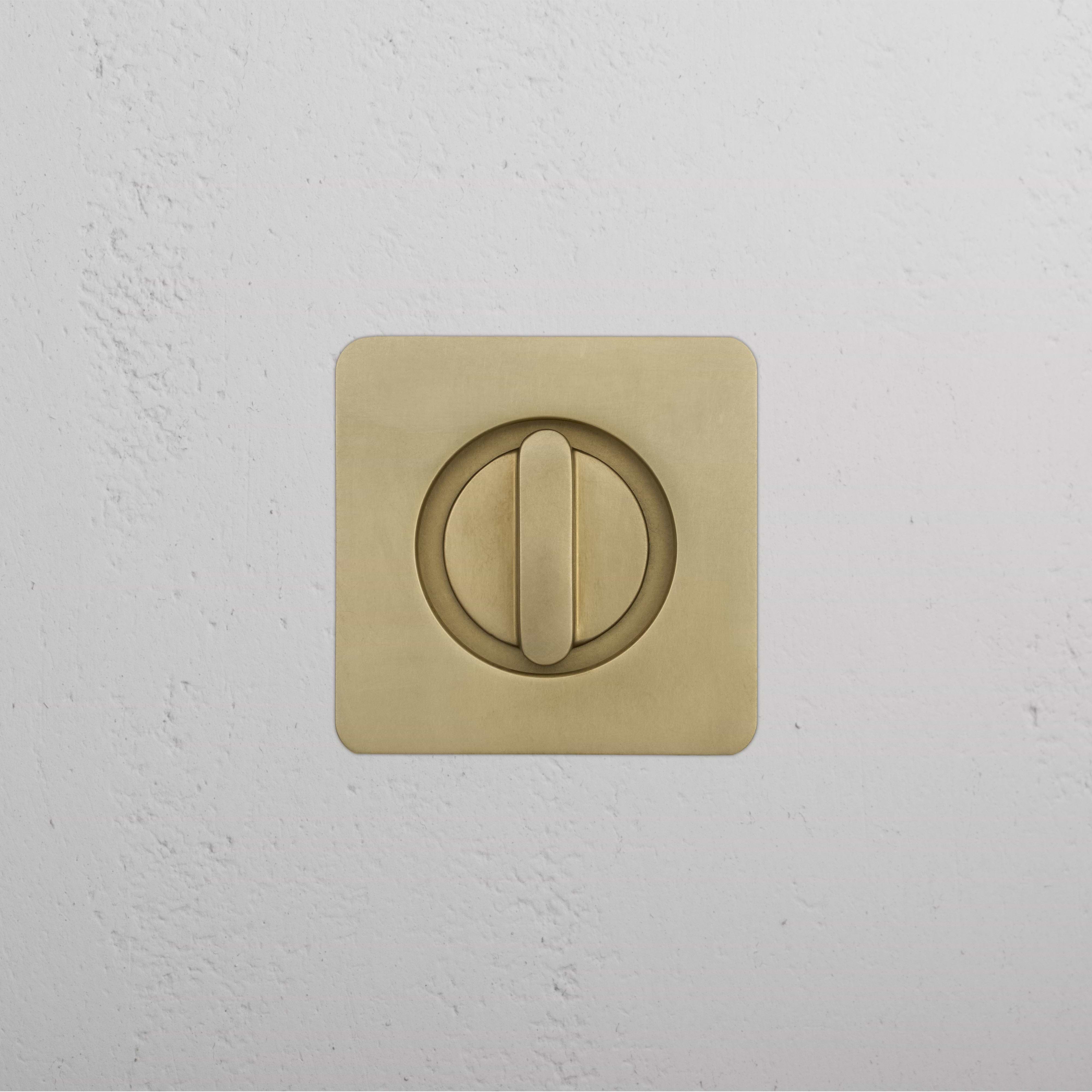 Regent Recessed Thumbturn brass lock on a textured white wall.