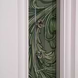 2G Architrave Two Way Toggle Switch in clear polished nickel on a green patterned wall with white trim.