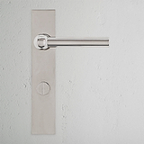 Harper Long Plate Sprung Door Handle & Thumbturn in polished nickel on a white textured wall.