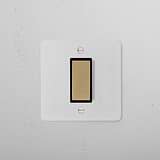 1G Centre Retractive Rocker Switch in paintable antique brass black on a textured white wall, combining style and function.