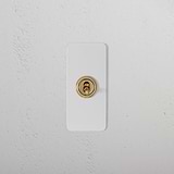 1G Architrave Retractive Toggle Switch in paintable antique brass on a textured white wall.