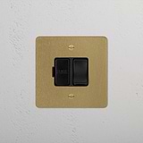 Antique Brass Black Switched Fused Spur (FCU) - Isolator Switch on a textured white wall.