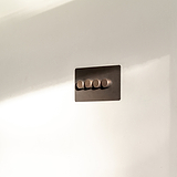 4G Two Way Dimmer Switch in bronze with four round knobs on a white wall. Elegant rectangular panel design.