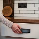 Bronze Elm Cup Handle 164mm on a kitchen drawer, against a backdrop of white tiles.
