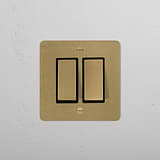 Antique Brass Black 2G two-way rocker switch on a white textured wall, part of 2G Switches & Dimmers collection.