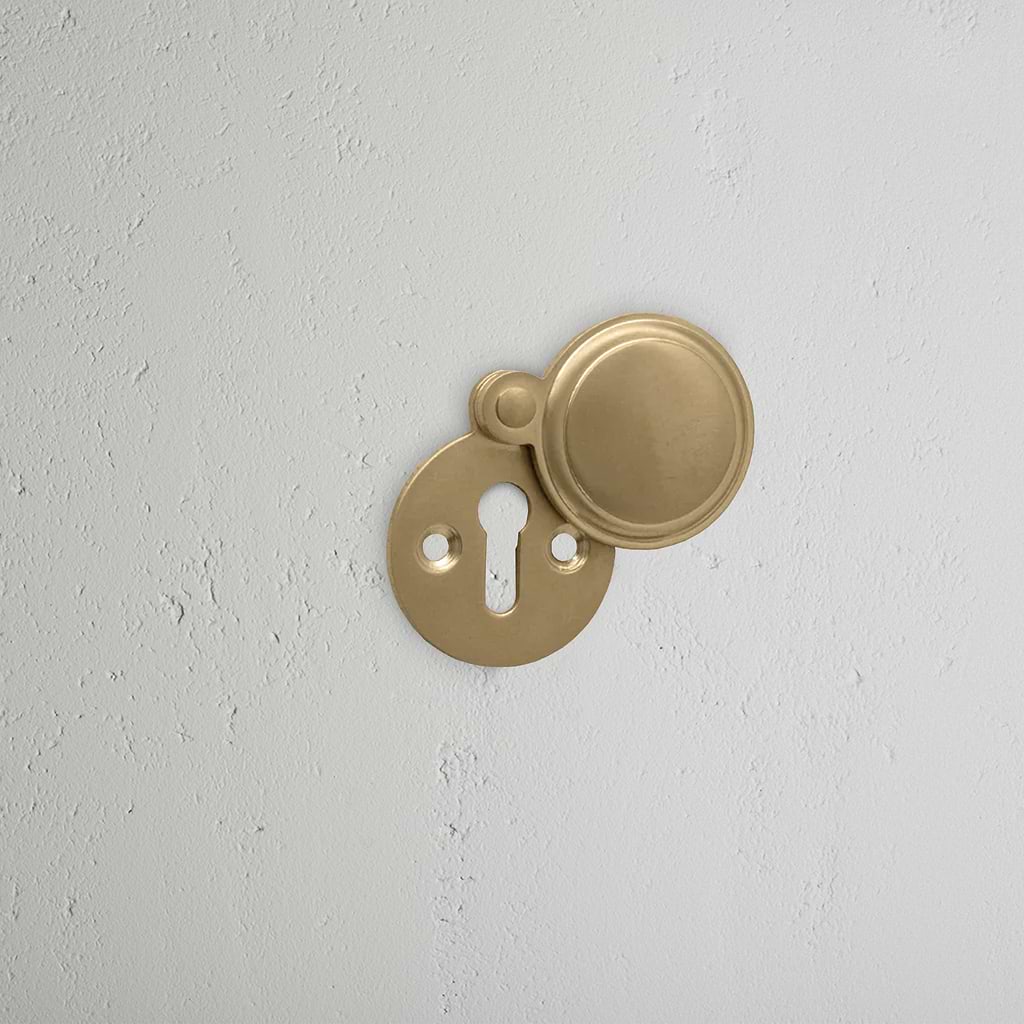 Antique Brass Canning Covered Key Escutcheon on White Background