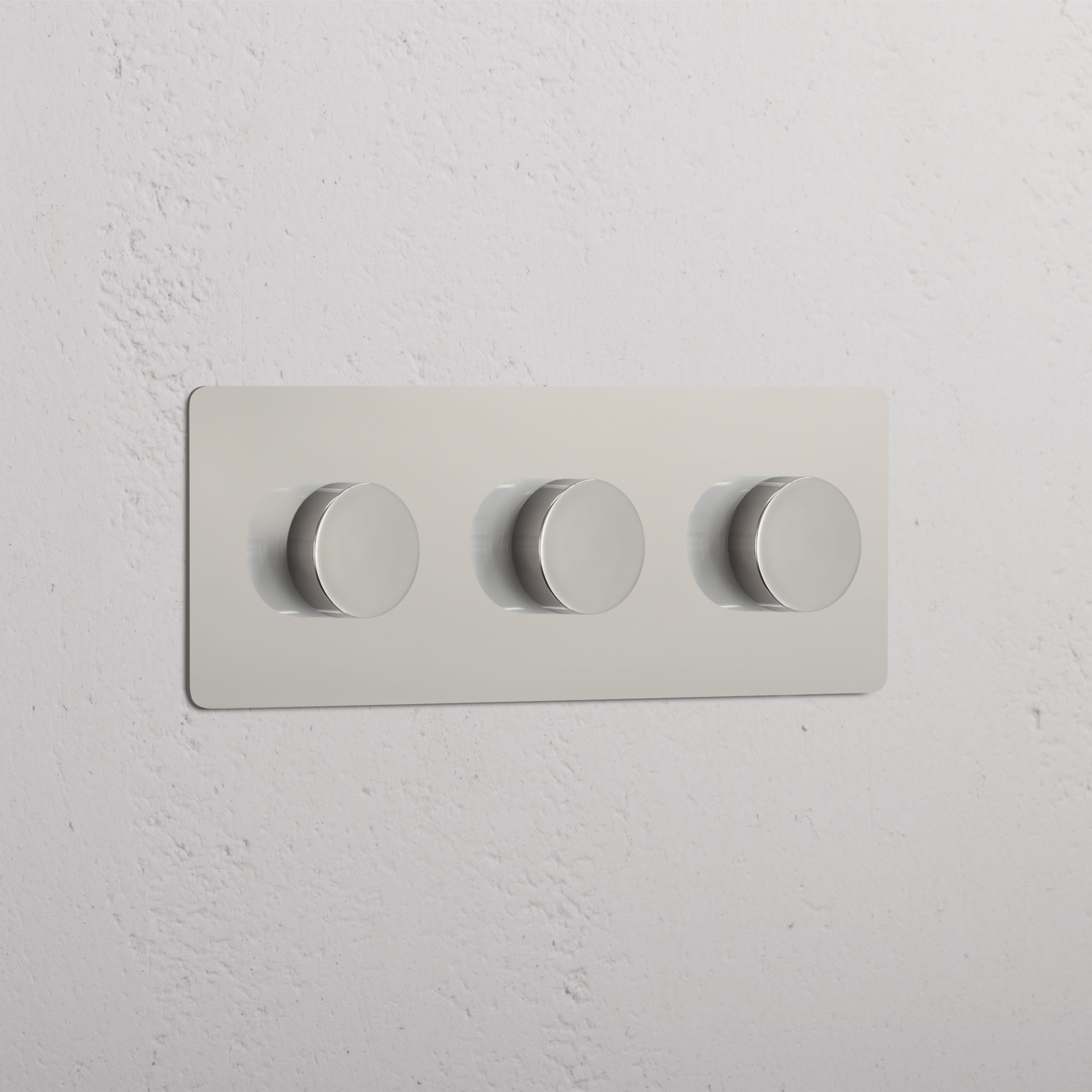 Dreifachrahmen mit 3x Mehrpunkt-Dimmerschalter in poliertem Nickel, horizontal an weißer Wand montiert.