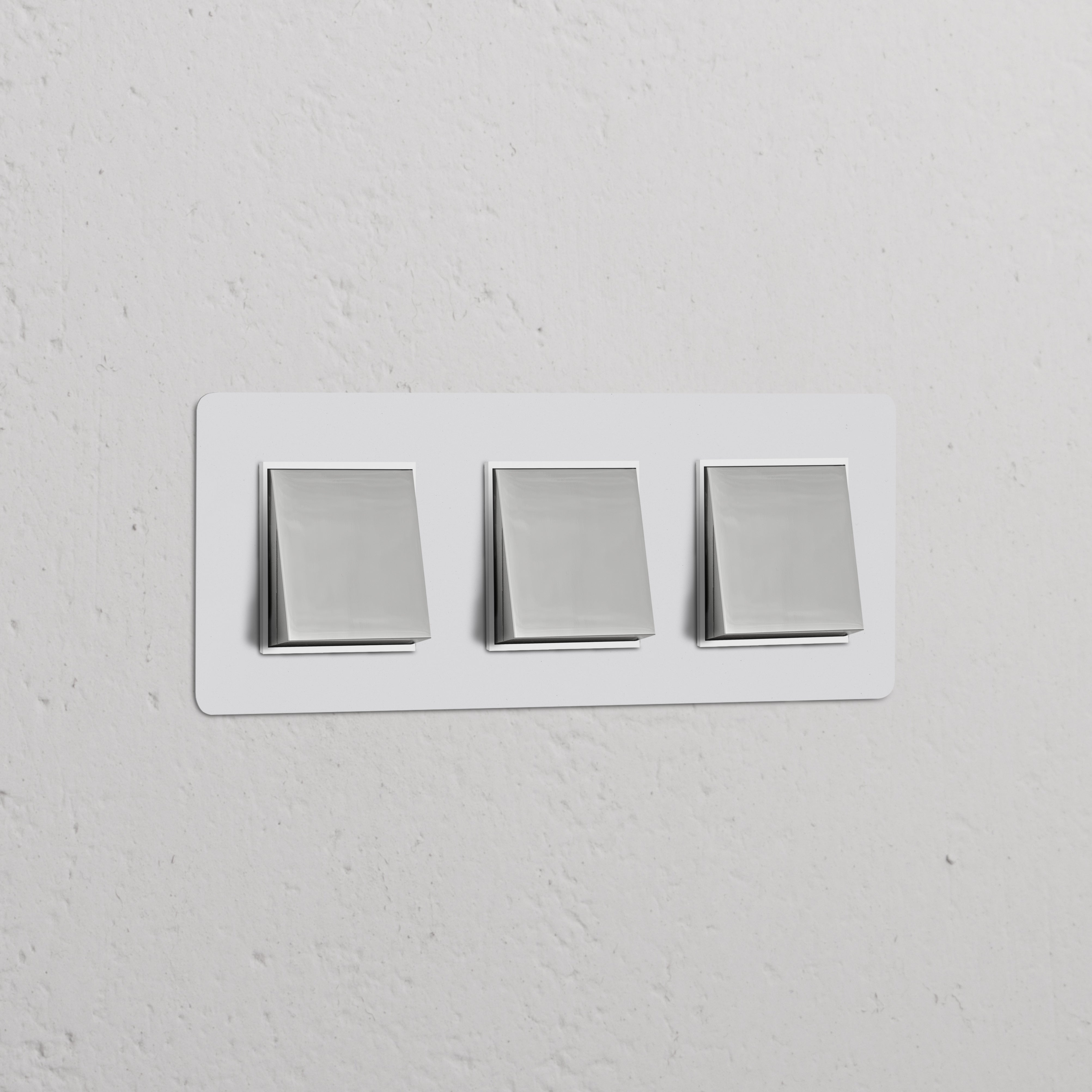 Dreifachrahmen mit 3x Wippschalter in lackierbar, poliertem Nickel und Weiß auf strukturierter weißer Wand.