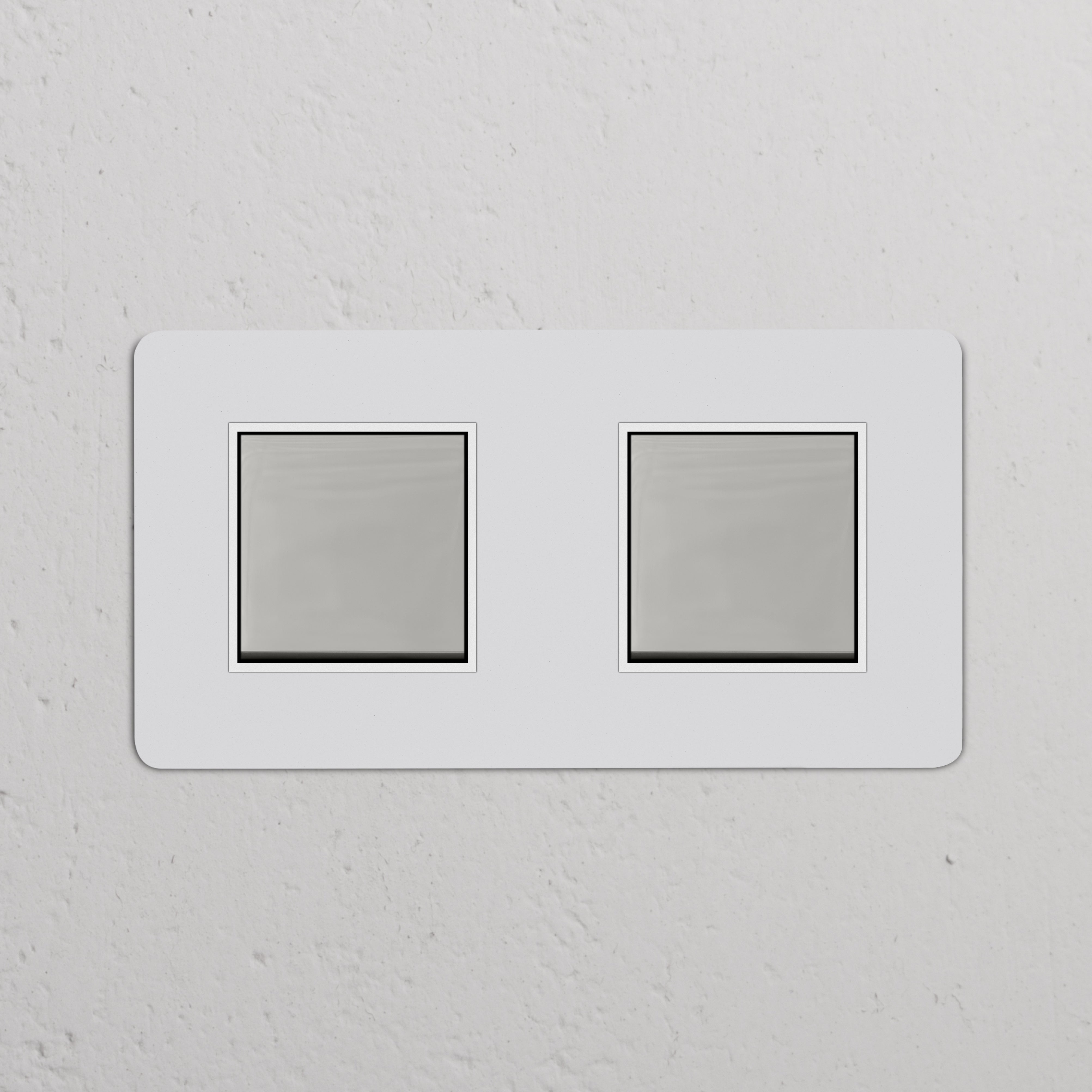 Zweifachrahmen mit 2x Wippschalter – lackierbar, poliertes Nickel, weiß – auf einer weißen Wand montiert.