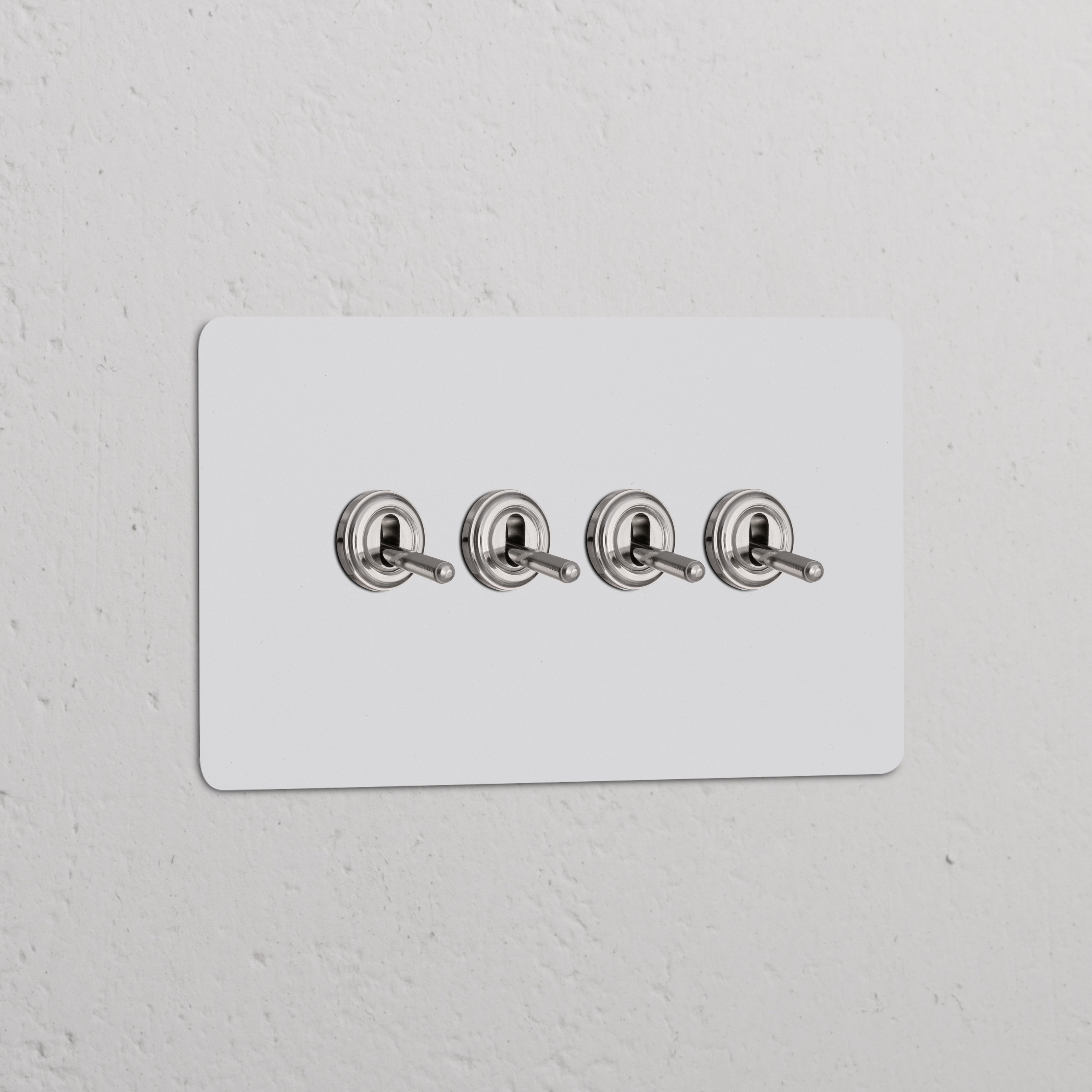 Zweifachrahmen mit 4x Kipphebelschalter, lackierbar, poliertes Nickel, auf weißem Wandpaneel.