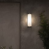 Mittlere Wandleuchte Bank Riffelglas in poliertem Nickel mit geriffeltem Glas, montiert an grauer Wand.